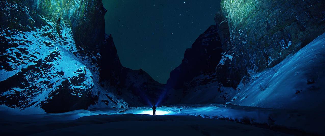晚上雪山星夜男人手电筒光带鱼屏高清壁纸