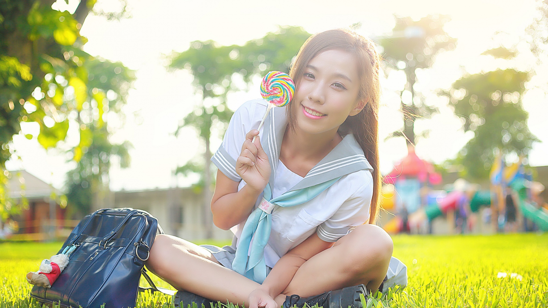 坐在草地上的微笑的脸儿女孩甜蜜快乐桌面高清壁纸